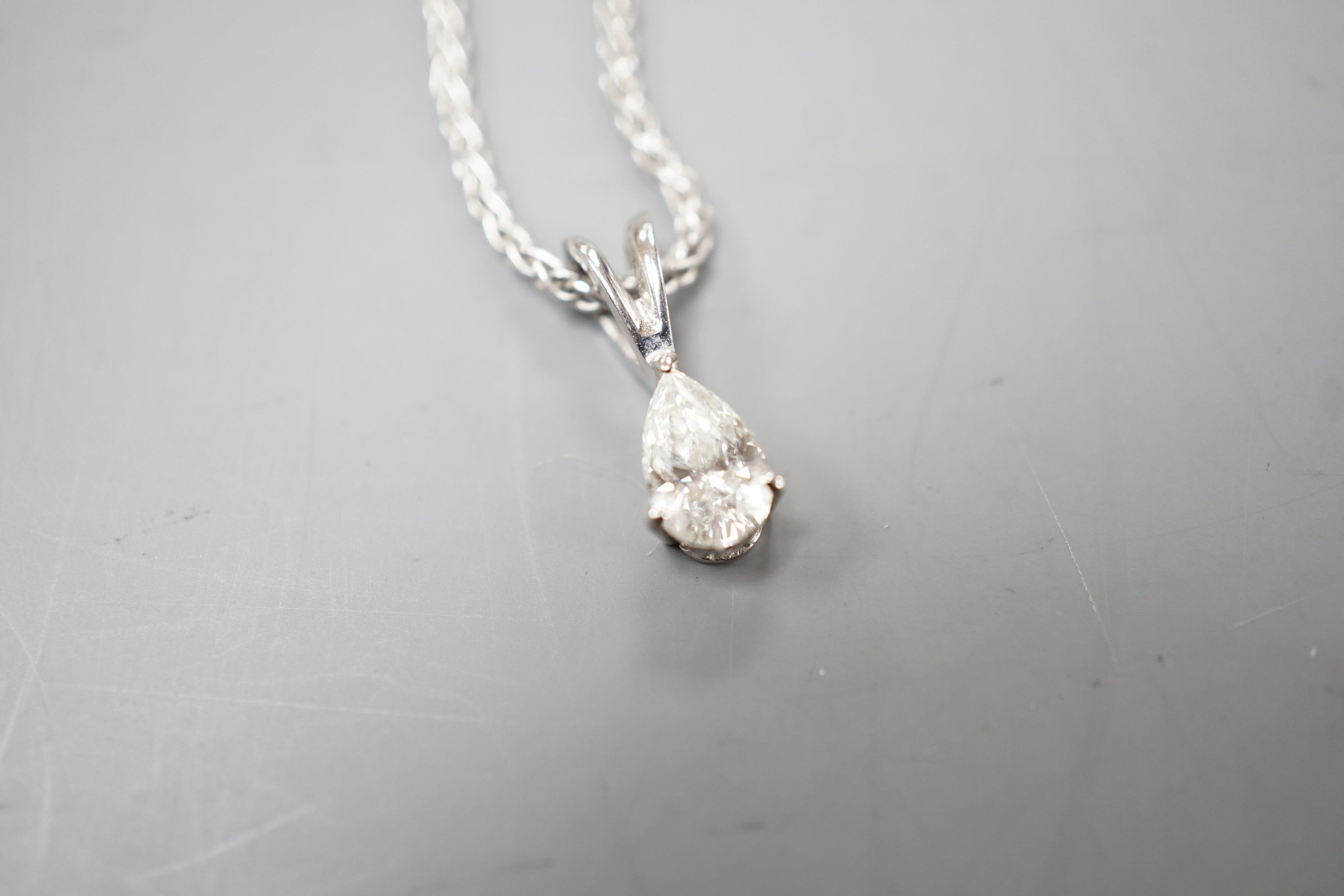 A modern white metal and pear cut diamond set pendant, 13mm, on an 18ct white gold chain, 39cm, gross weight 4.5 grams.